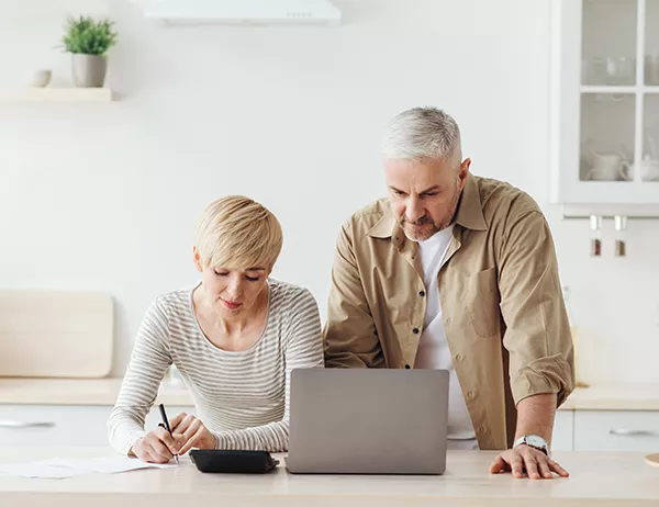 Couple looking at laptop researching secured and unsecured loans